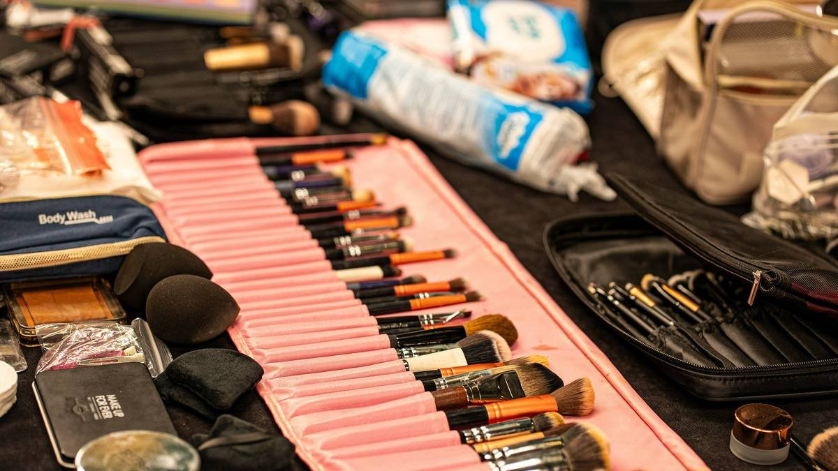 Comparison chart showing durability, weight, and cleanability of common makeup bag materials: nylon, vegan leather, polyester, and cotton