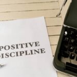 a piece of paper that says positive discipline next to a typewriter