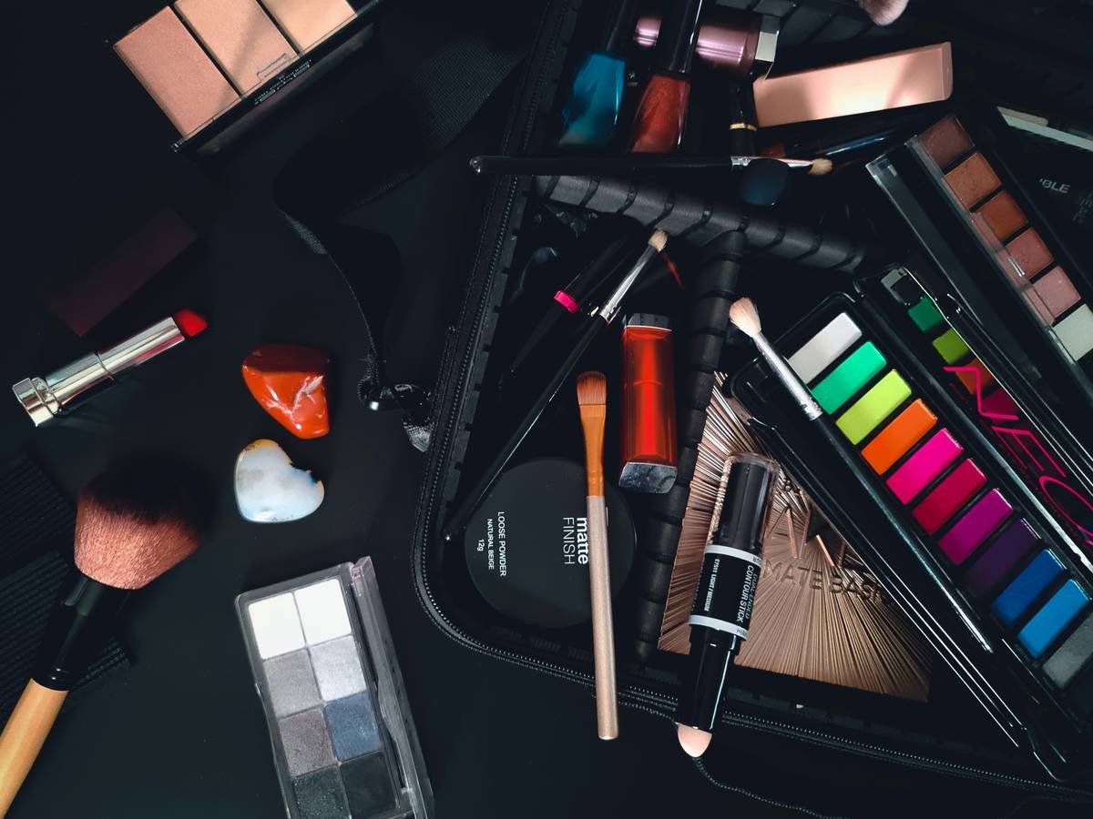 Infographic showing 3-category system for makeup bag organization: Daily Essentials (foundation, mascara, lip balm), Occasional Use (glitter, bold lipsticks), Toss Pile (dried products, expired items)
