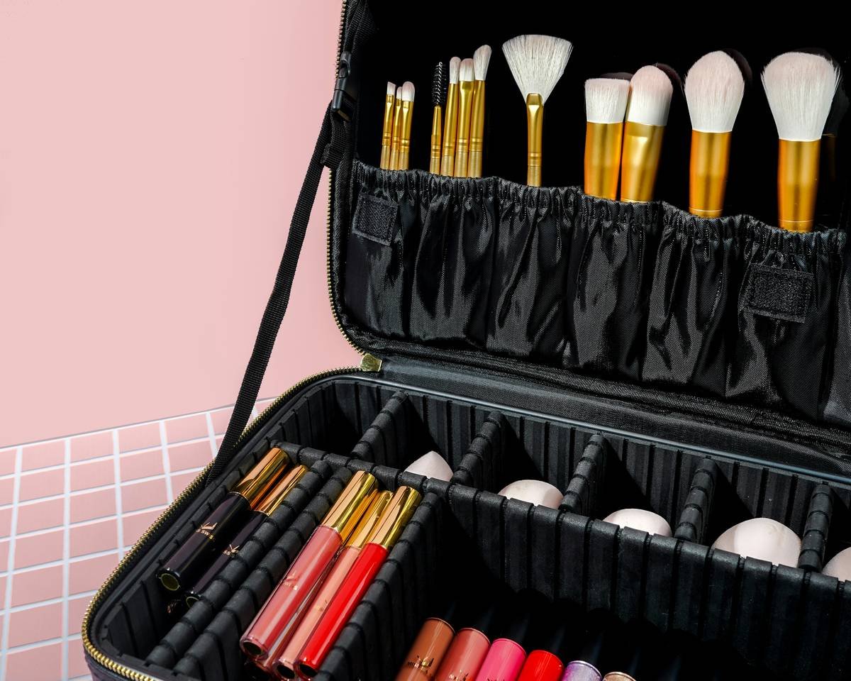 Organized makeup essentials case with labeled compartments for foundation, brushes, and lip products