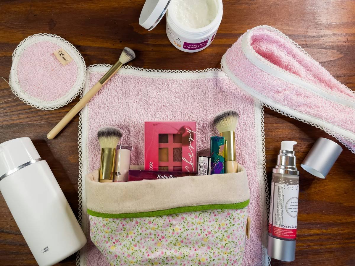 Open beauty travel case showing organized makeup brushes, skincare vials, and sealed liquid pods
